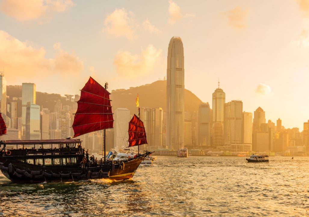 Chinese wooden red sails ship in Hong Kong Victoria harbor at sunset time