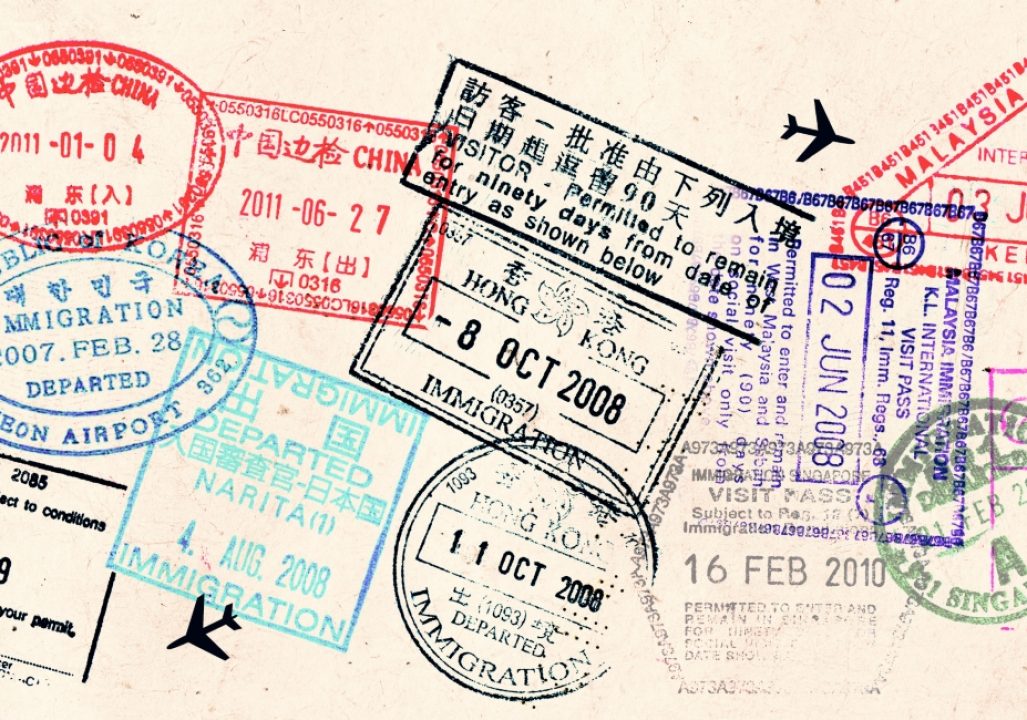 Passport visas stamps on sepia textured, vintage travel collage background