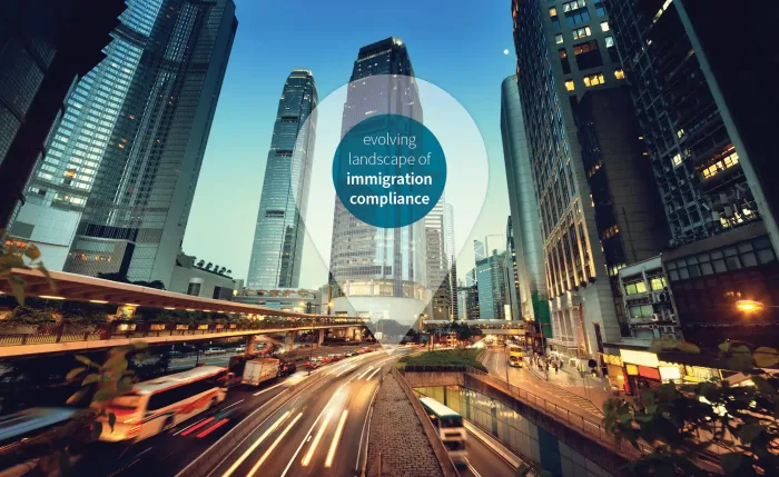 City street at night with tall buildings, and a bustling road. Text reads 