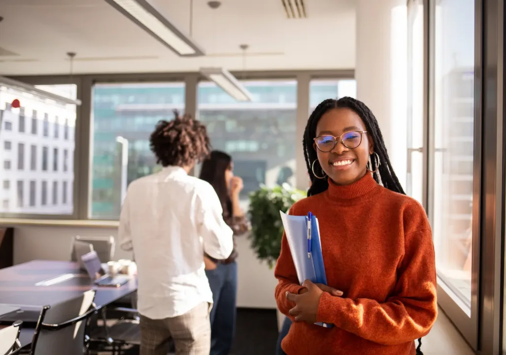 Student in a red sweater smiling at the camera