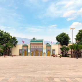 Royal Palace in Fes, Morocco with ornate golden gates and green-tiled roofs.