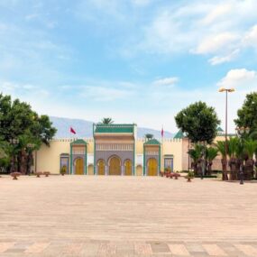 Royal Palace in Fes, Morocco with ornate golden gates and green-tiled roofs.