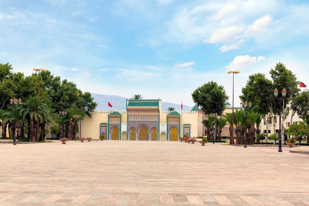 Royal Palace in Fes, Morocco with ornate golden gates and green-tiled roofs.