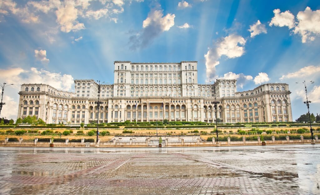 Bucharest, Romania, featuring the Palace of the Parliament under a partly cloudy sky.