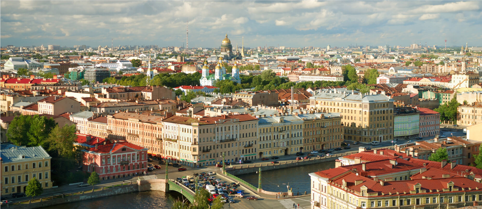 Saint Petersburg, Russia. It shows a cityscape with numerous historic buildings, a golden-domed cathedral, and a river with a bridge and cars.
