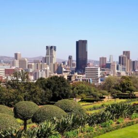 South Africa. It shows a cityscape with various high-rise buildings and green spaces in the foreground.