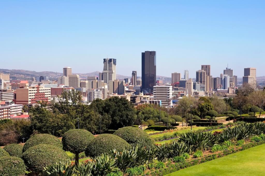 South Africa. It shows a cityscape with various high-rise buildings and green spaces in the foreground.