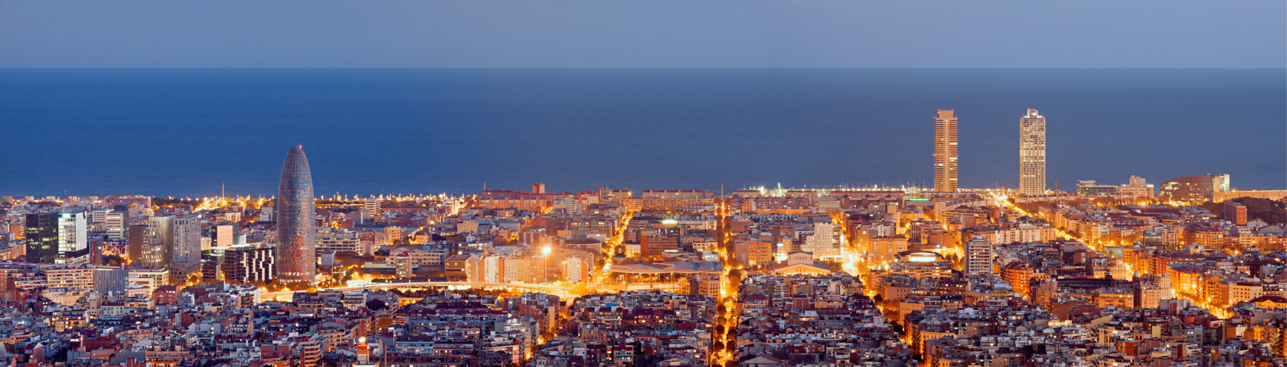 city of Barcelona at dawn, illuminated by city lights