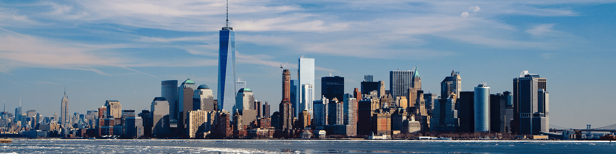 United States, New York City, skyline of Lower Manhattan, including the One World Trade Center, across a body of water.