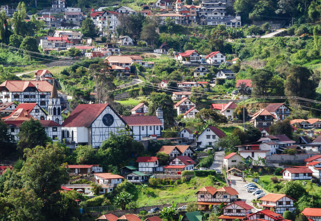 Venezuela, a town with distinctive half-timbered houses with red roofs nestled in a green, mountainous landscape.