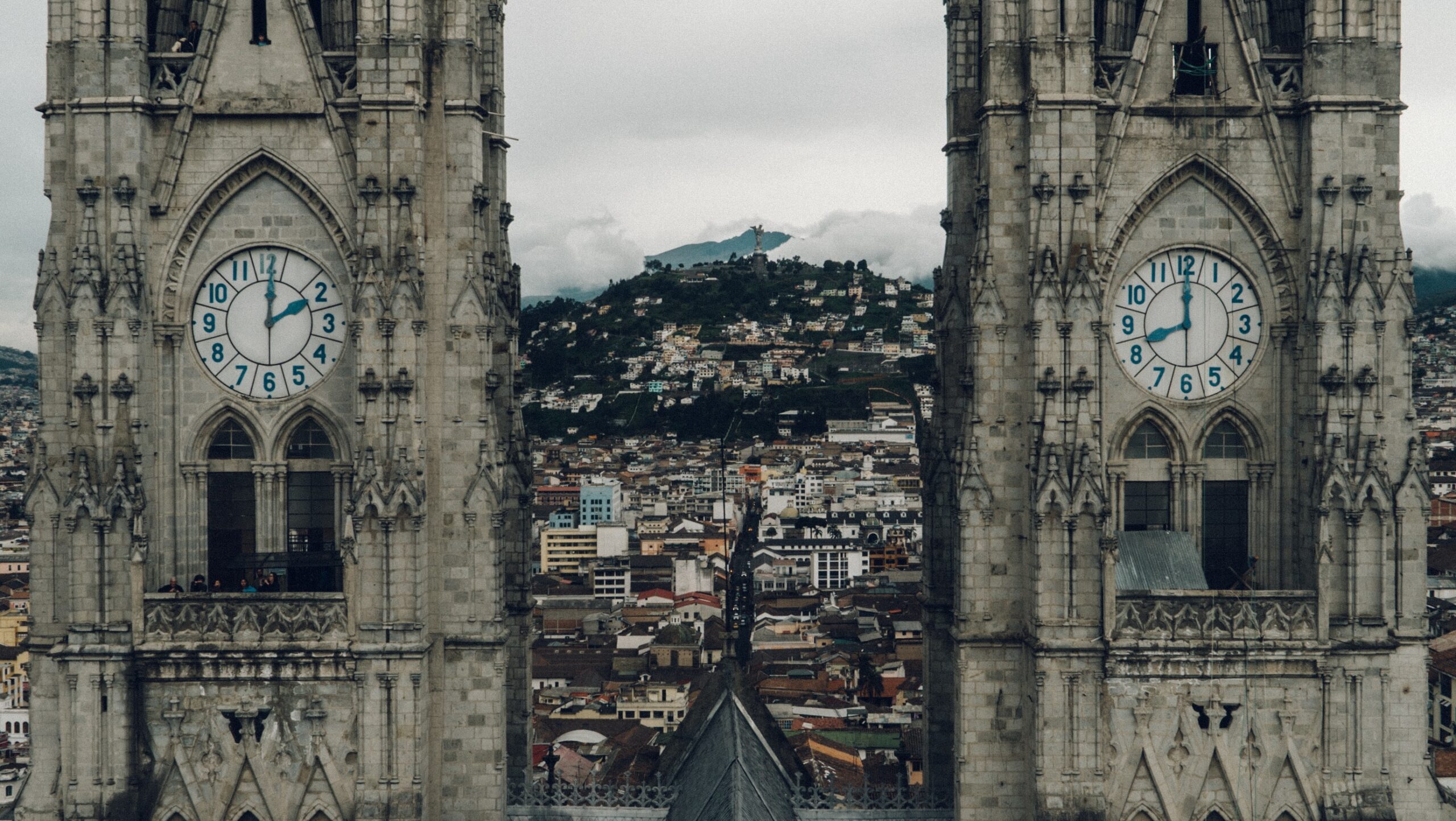 a view between the twin clock towers of the Basilica del Voto Nacional, looking out over the city of Quito, Ecuador.