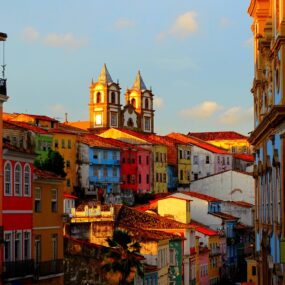 Town in El Salvador with colorful colonial buildings and prominent church towers at sunset.