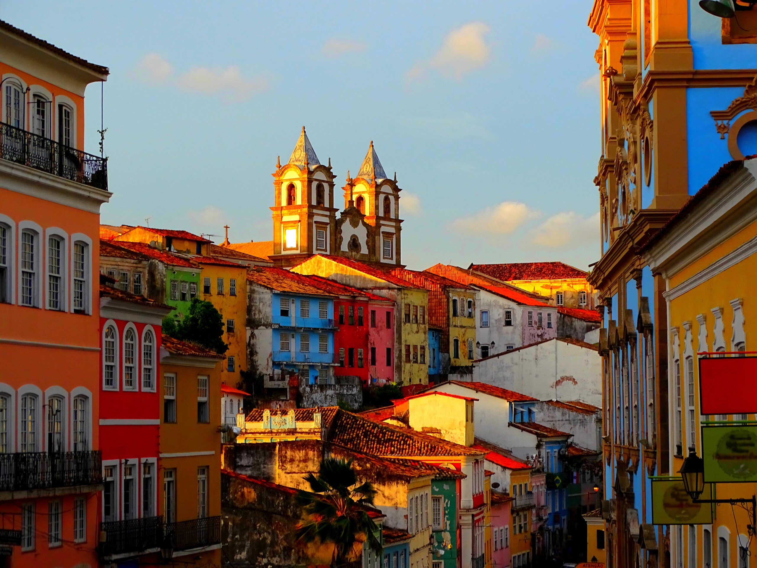 Town in El Salvador with colorful colonial buildings and prominent church towers at sunset.