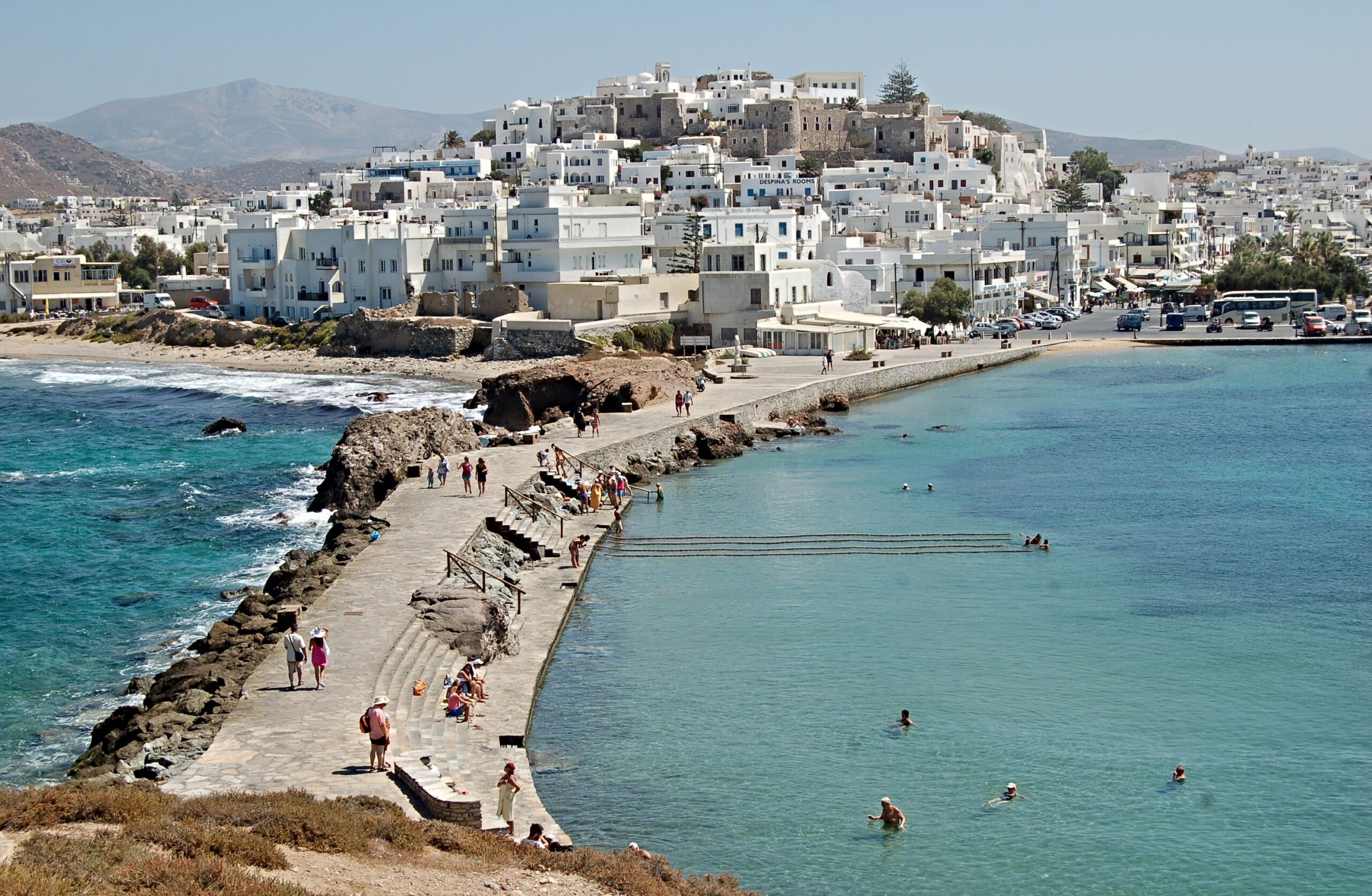 Naxos Town on the island of Naxos, Greece featuring distinctive white-washed architecture built on a hill, overlooking the turquoise waters of the Aegean Sea.