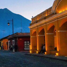 Antigua Guatemala, Guatemala featuring colonial architecture with cobblestone streets and a volcano in the background.