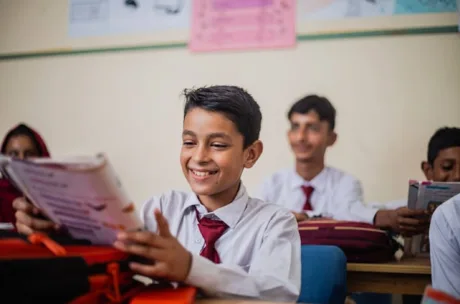 Schollchild reading a magazine in a classroom