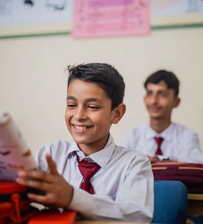 Schollchild reading a magazine in a classroom