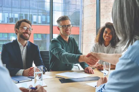 three smiling employees having a business conference