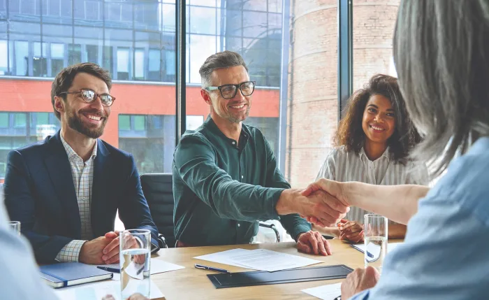 three smiling employees having a business conference