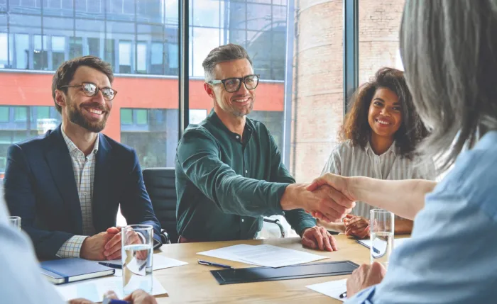 three smiling employees having a business conference