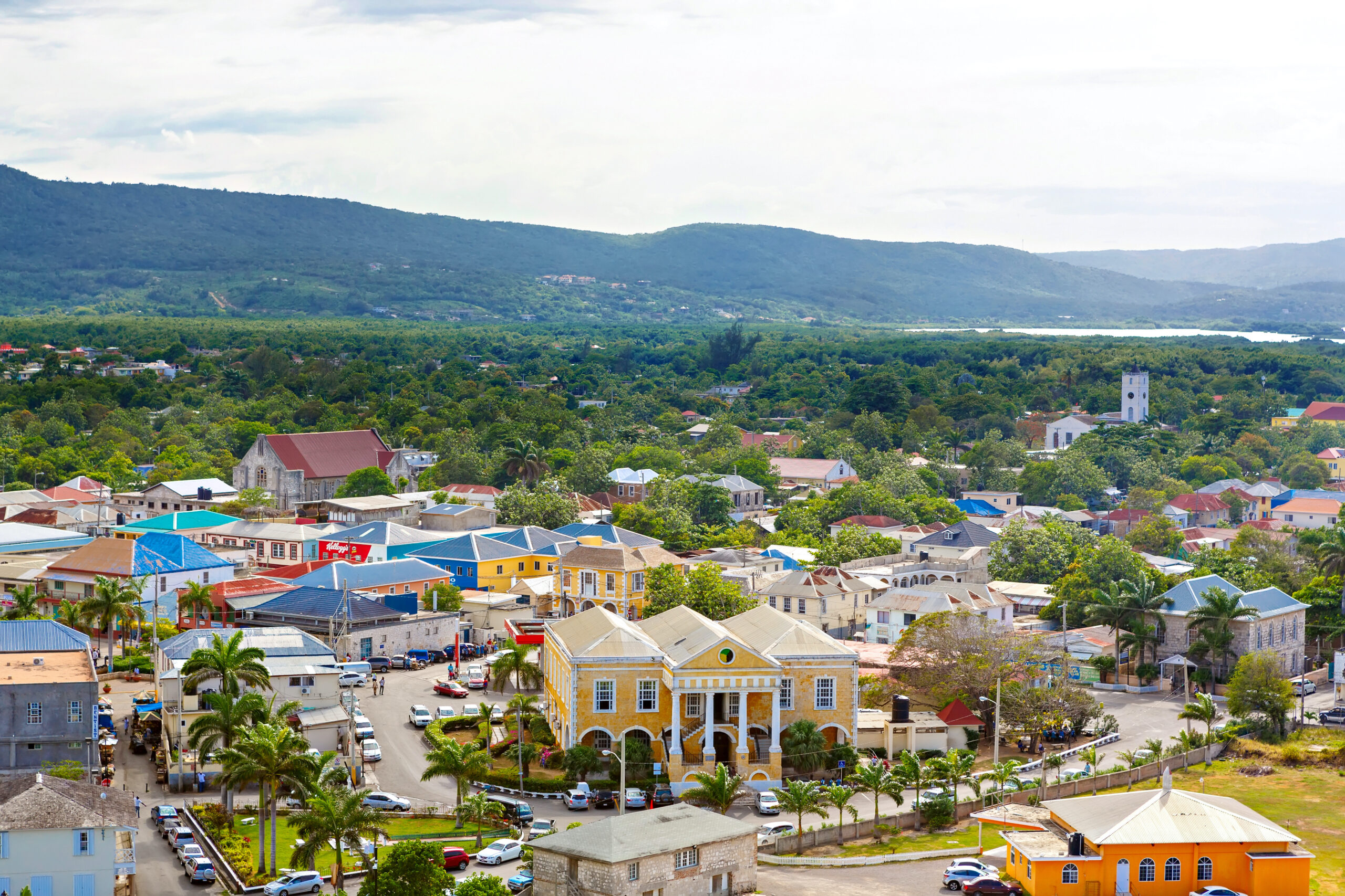 Charming town with colonial-era buildings in Falmouth, Jamaica. Colorful roofs, and lush green hills in the background.