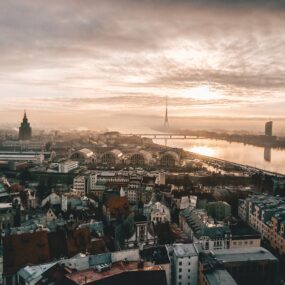 An aerial view of the Latvia, with the Daugava River, the Riga Radio and TV Tower in the distance.