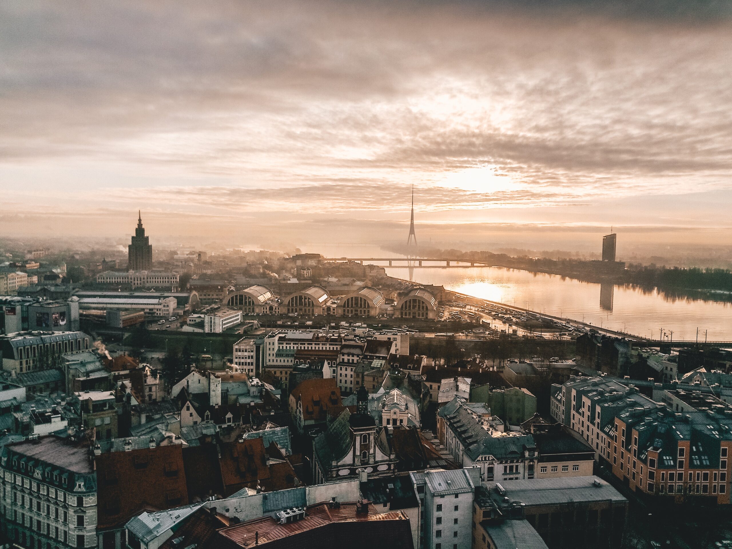 An aerial view of the Latvia, with the Daugava River, the Riga Radio and TV Tower in the distance.