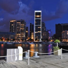 The modern skyline of Beirut, Lebanon, featuring a waterfront area with illuminated high-rise buildings and a marina at night.