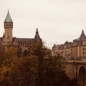 Luxembourg featuring Adolphe Bridge and the surrounding historic buildings and lush autumnal trees in a sepia tone.
