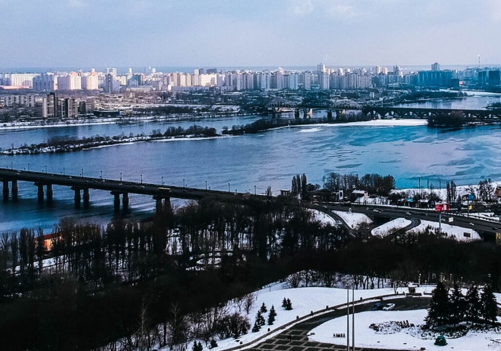 Ukraine, a wide river, with several bridges spanning it, and a cityscape with many buildings on both banks.