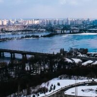 Ukraine, a wide river, with several bridges spanning it, and a cityscape with many buildings on both banks.
