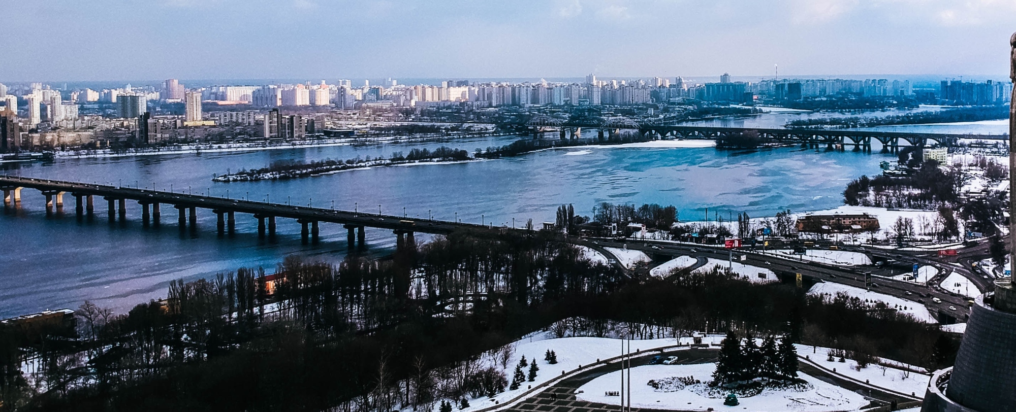 Ukraine, a wide river, with several bridges spanning it, and a cityscape with many buildings on both banks.