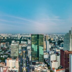 Vietnam, modern cityscape with numerous high-rise buildings, under a clear sky at dusk.