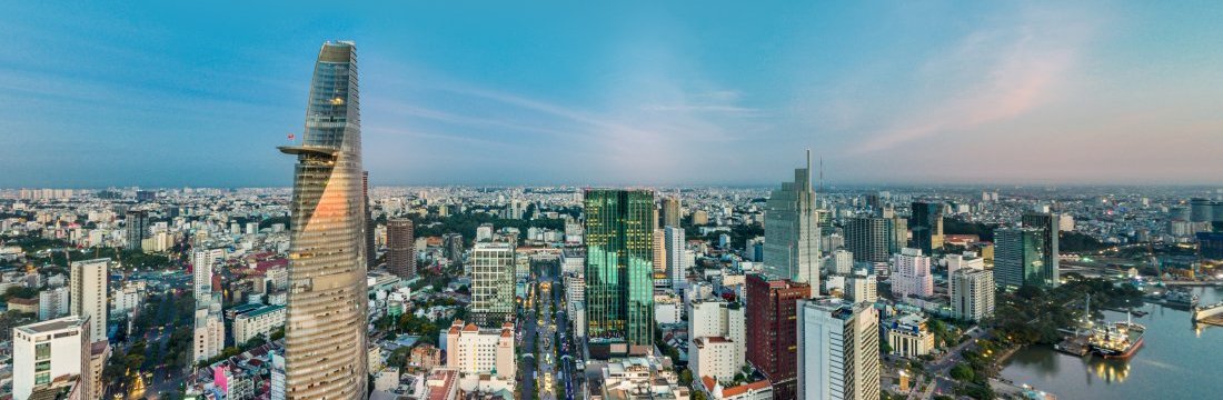 Vietnam, modern cityscape with numerous high-rise buildings, under a clear sky at dusk.