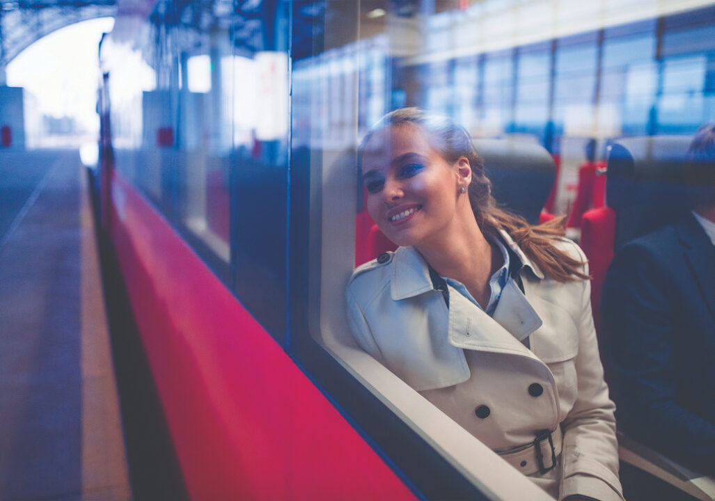 smiling woman sitting on a train