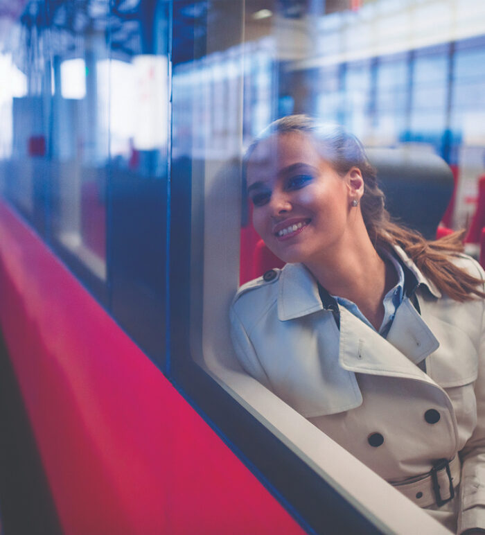 smiling woman sitting on a train