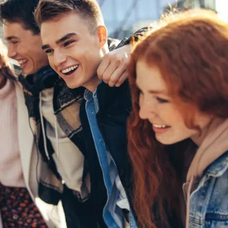Group of people smiling and enjoying themselves outside in the sunlight.