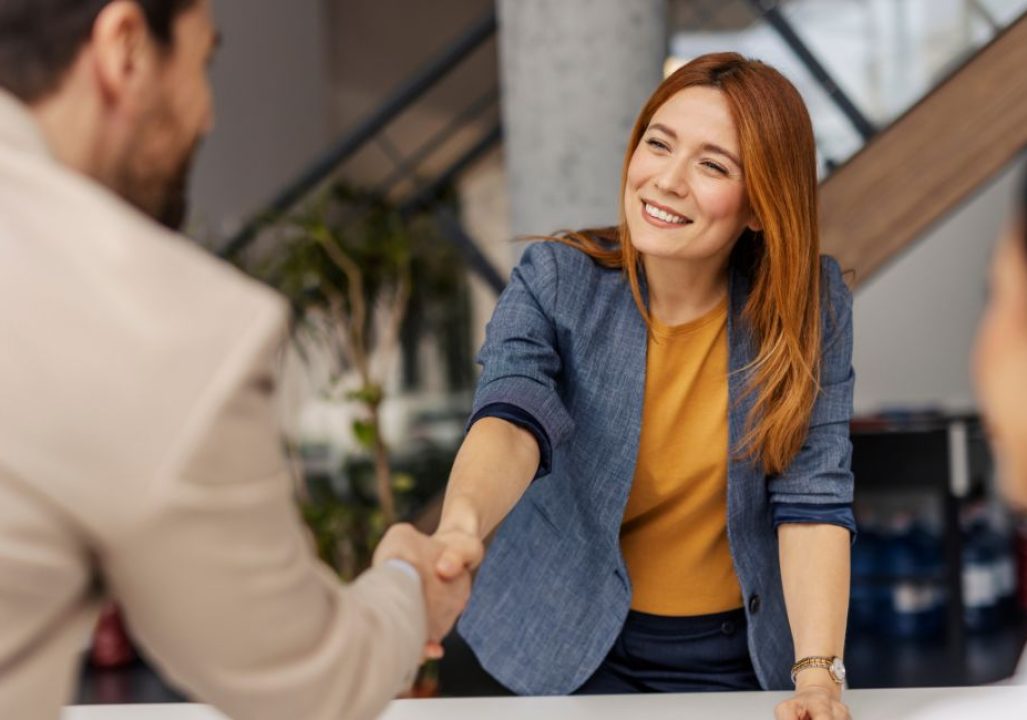 Smiling boss shakes hands with colleague