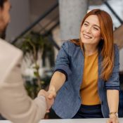 Smiling boss shakes hands with colleague