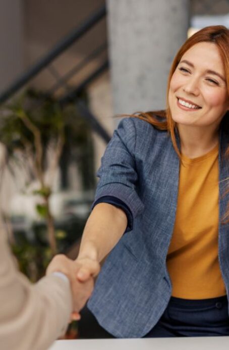 Smiling boss shakes hands with colleague