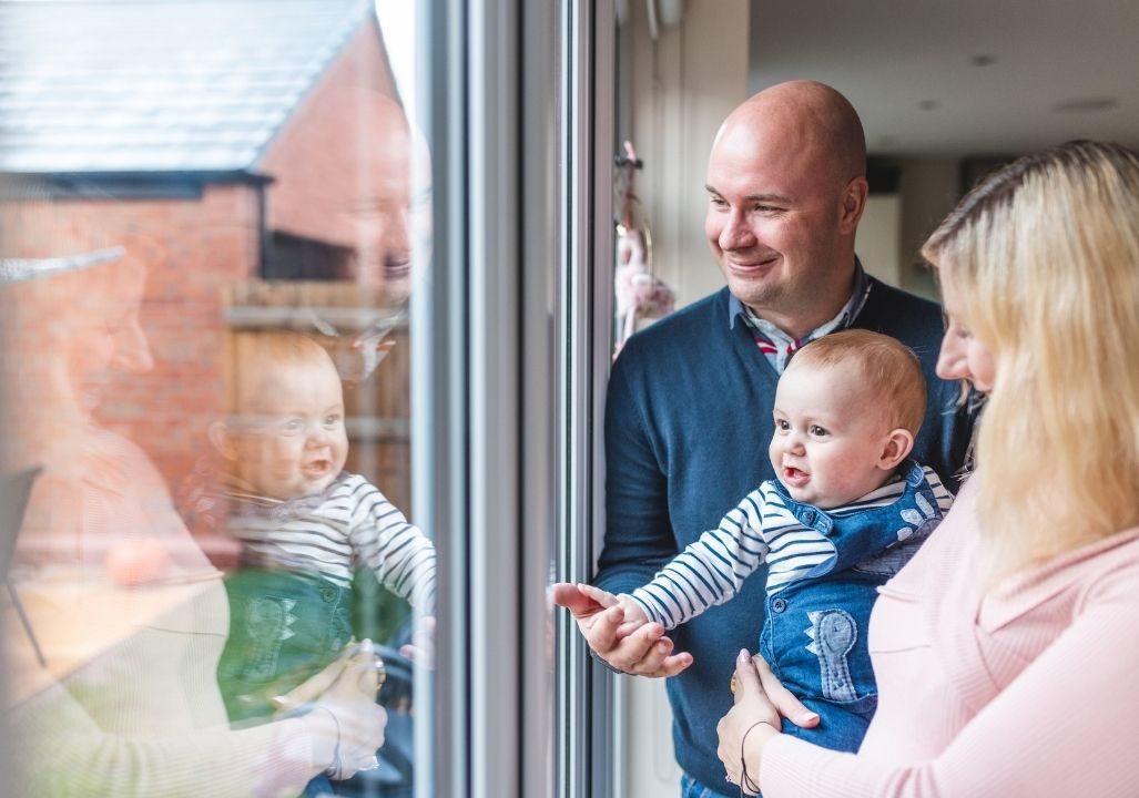 Smiling parents at home with baby