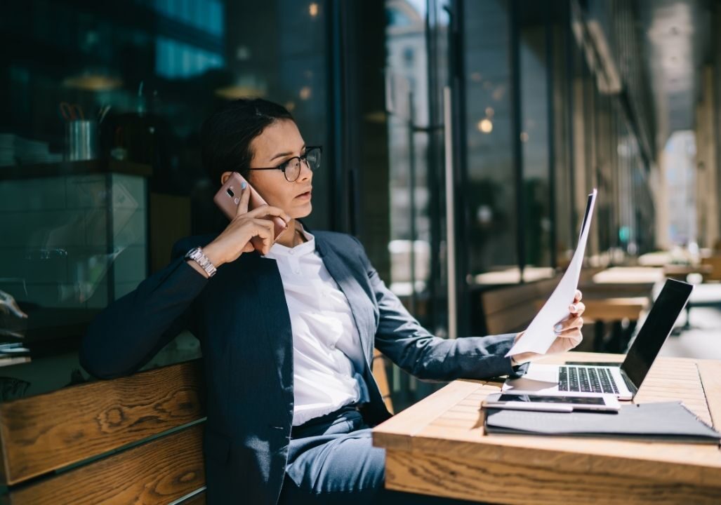 Busy female calling on mobile phone during remote work