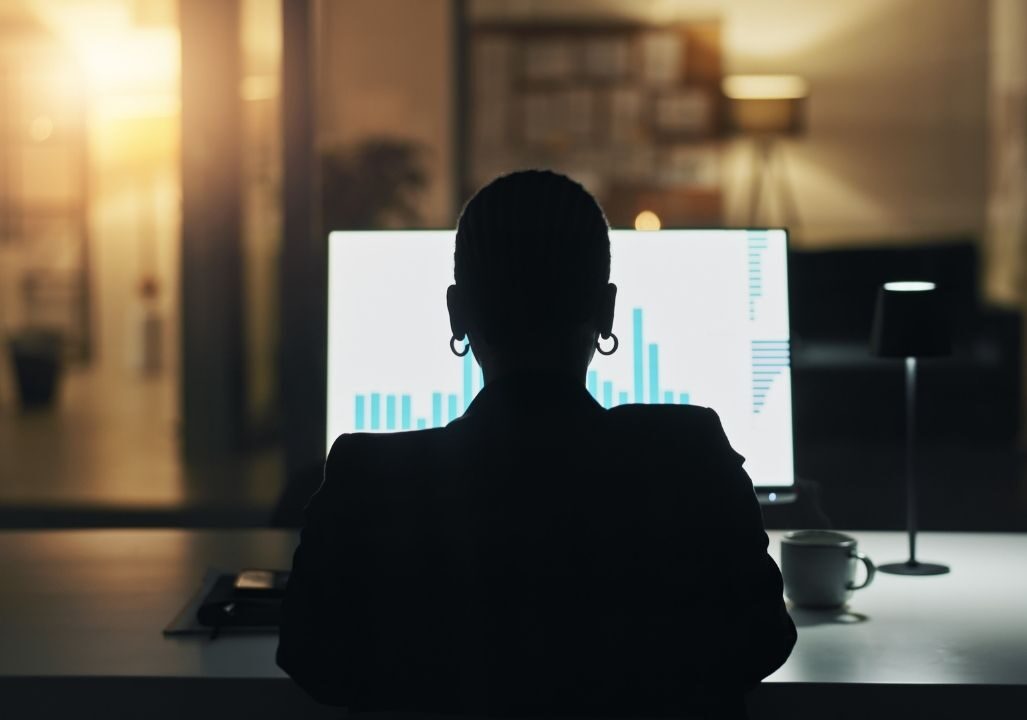 Business person, computer screen and night at office with finance graphs
